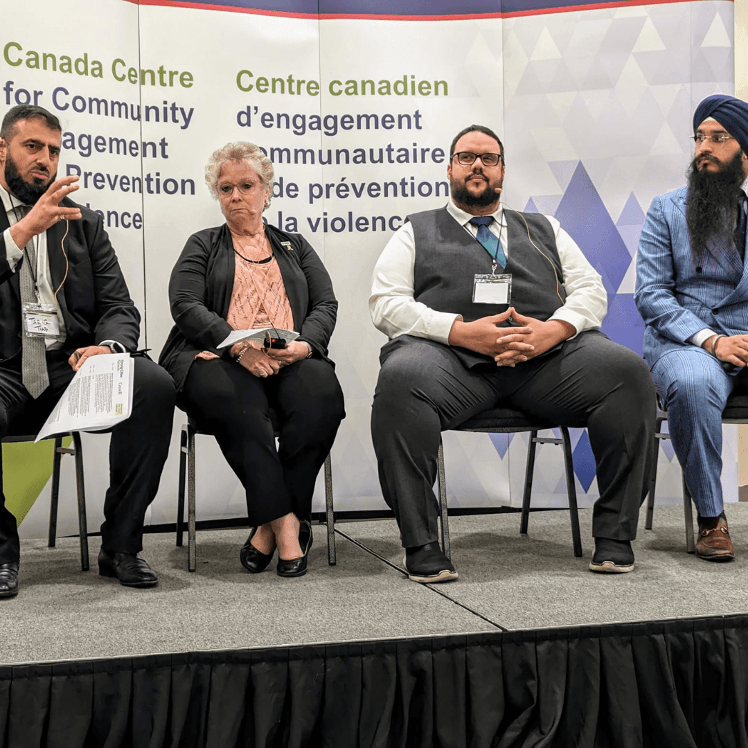 Panel discussion at Canada Centre for Community Engagement with four people seated on stage.